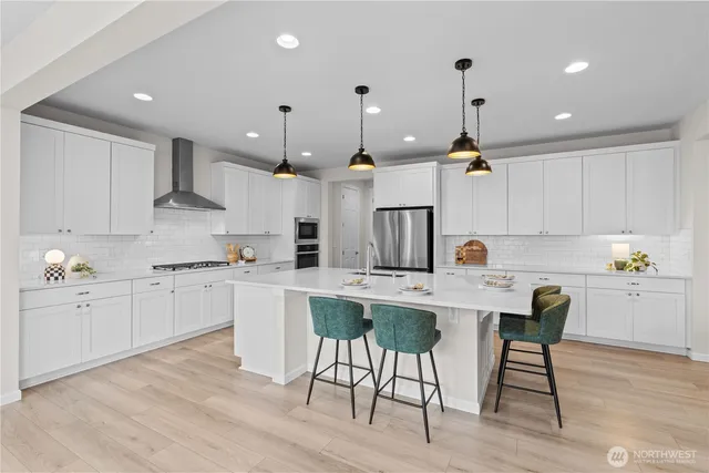 a kitchen with white cabinets and chairs