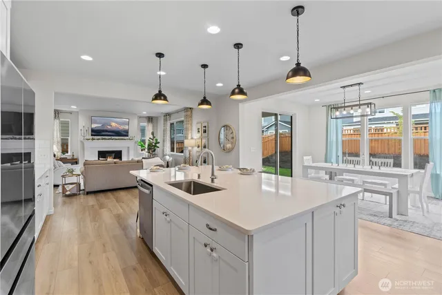 a large kitchen with kitchen island a large counter space a sink appliances and living room view