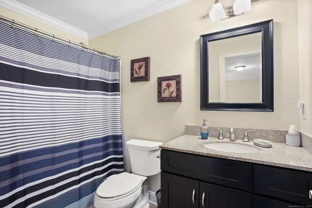 a bathroom with a sink vanity mirror and toilet