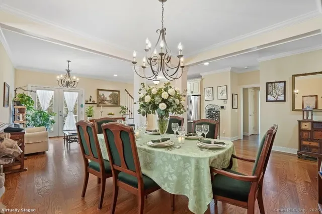 a view of a dining room with furniture a chandelier and wooden floor