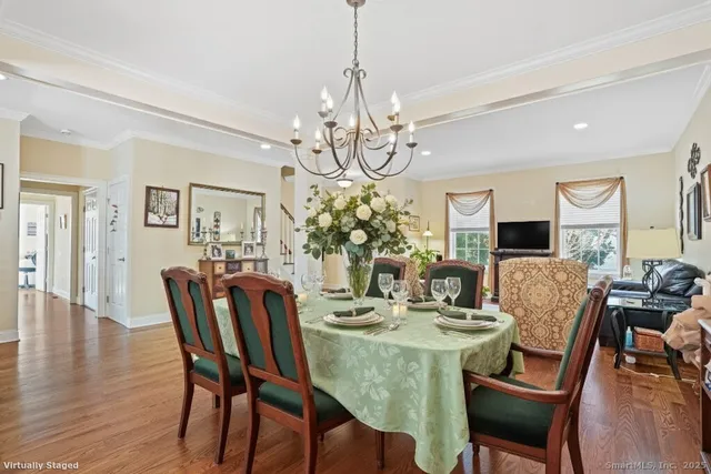 a view of a dining room with furniture a chandelier and wooden floor