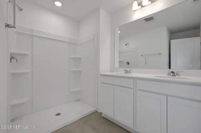 a bathroom with a shower sink and mirror