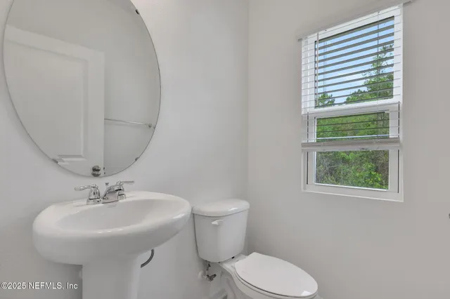 a bathroom with a sink toilet and a mirror