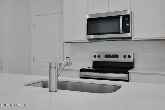 a view of living room with microwave and stove