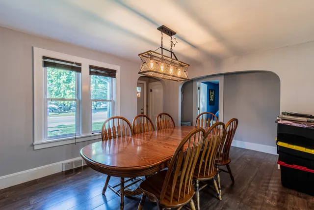 a dining room with furniture a chandelier and wooden floor