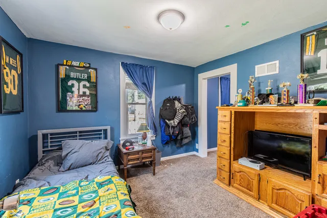 a bedroom with furniture and a flat screen tv