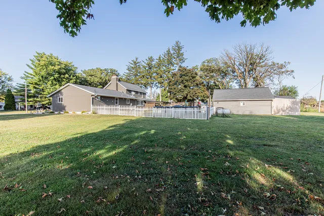 a view of a house with backyard and sitting area