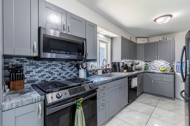 a kitchen with stainless steel appliances granite countertop a stove sink and cabinets
