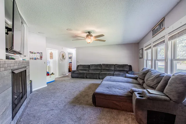 a living room with furniture a fireplace and a flat screen tv