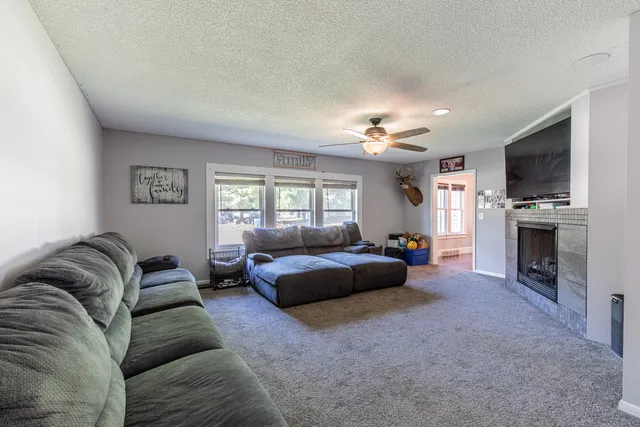 a living room with furniture a fireplace and a flat screen tv