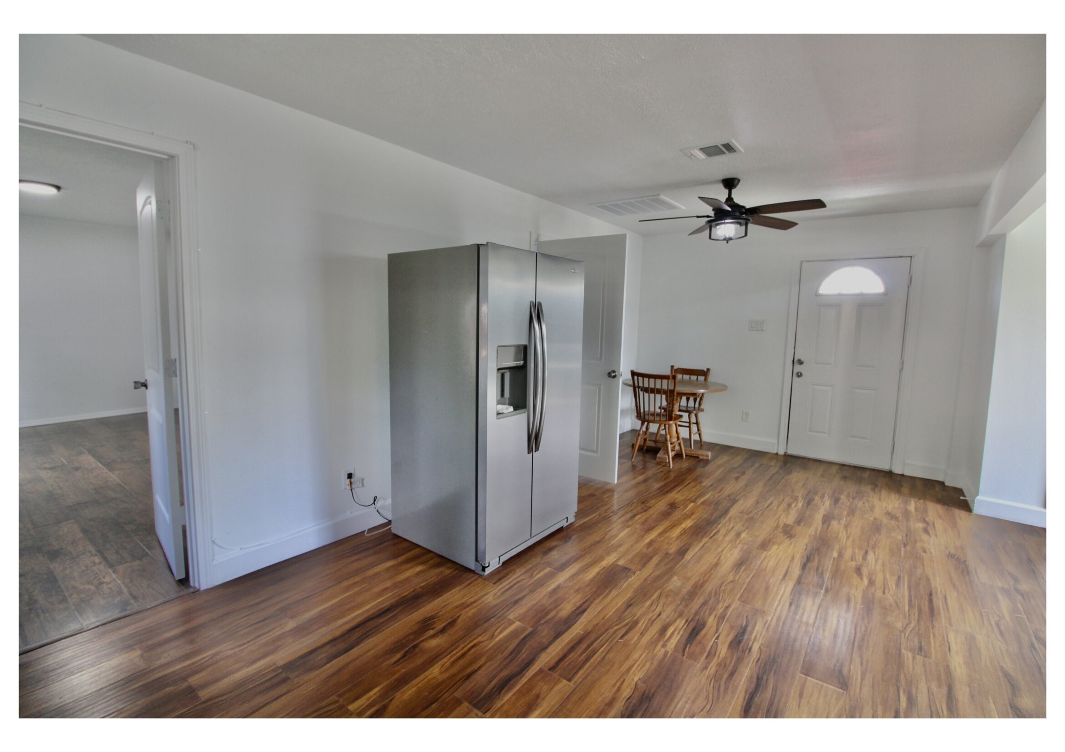 409 Robert Lee Road Houston, TX 77009 - Photo 12 of 32 Warm, Wood-Look Flooring: The space features durable, rich-toned laminate flooring throughout, providing a sleek foundation for any design style.