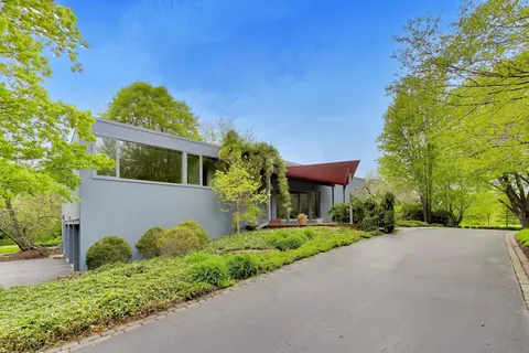 a front view of a house with a yard and trees