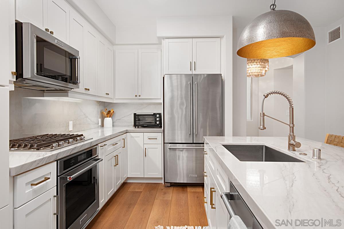 a kitchen with stainless steel appliances a stove a sink a refrigerator and cabinets