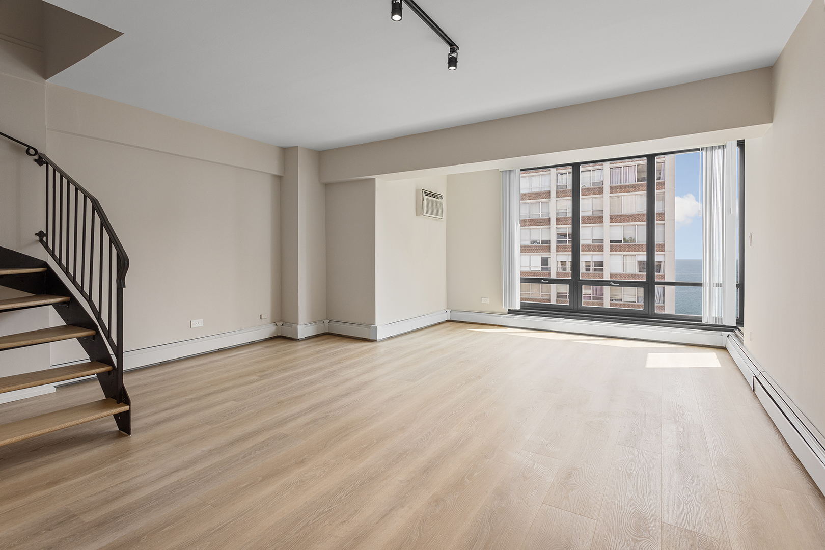 6166 North Sheridan Road, Unit 4G Chicago, IL 60660 - Photo 2 of 24 a view of an empty room with wooden floor and a window