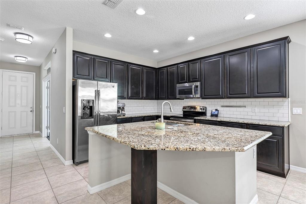 7644 Ripplepointe Way Windermere, FL 34786 - Photo 4 of 52 a kitchen with stainless steel appliances granite countertop a sink stove and refrigerator
