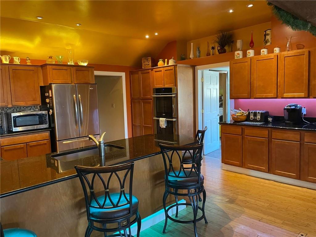 4199 Morgantown Road Smithfield, PA 15478 - Photo 13 of 34 a kitchen with stainless steel appliances granite countertop a refrigerator a stove and a dining table with wooden floor