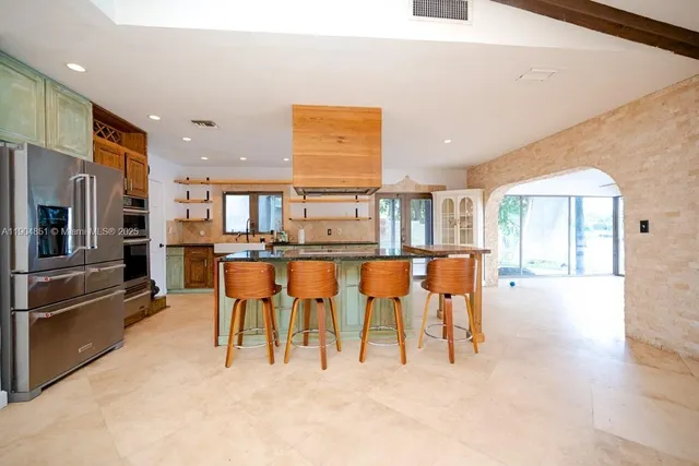 a open kitchen with stainless steel appliances kitchen island granite top and refrigerator