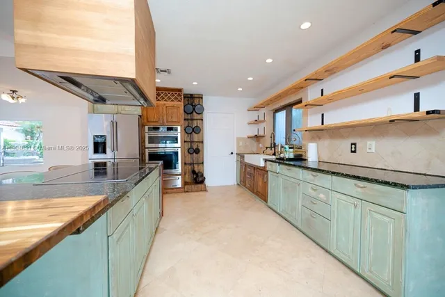 a large kitchen with stainless steel appliances kitchen island a large counter top and a sink