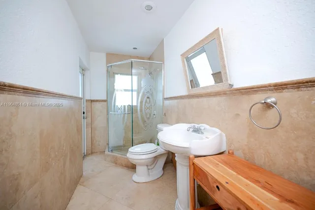 a bathroom with a toilet a sink and shower