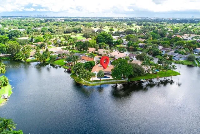 an aerial view of a house with a garden and lake view
