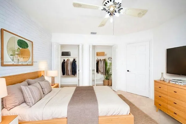 a bedroom with a bed and a flat tv screen on dresser