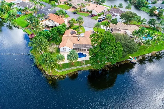 an aerial view of a house with garden space and lake view