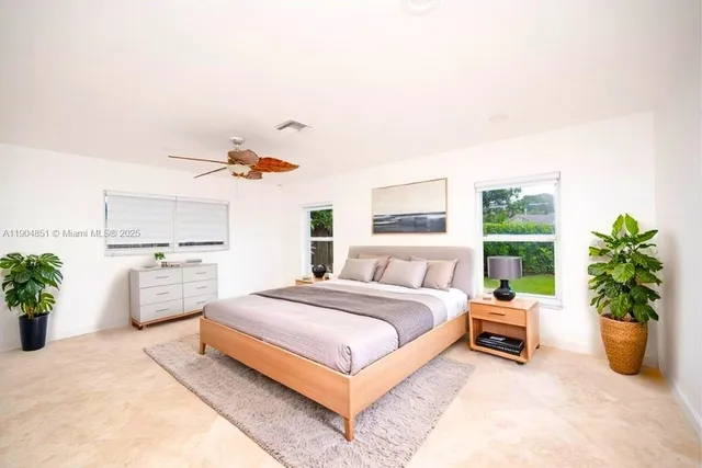 a bedroom with a bed potted plant with the view of kitchen