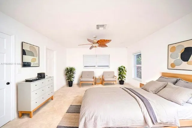 a bedroom with a bed and a large window