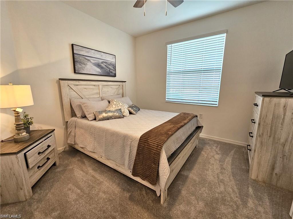 5807 Double Eagle Cir Avenue, Unit 4621 Immokalee, FL 34142 - Photo 21 of 46 Bedroom featuring baseboards, a ceiling fan, and dark colored carpet
