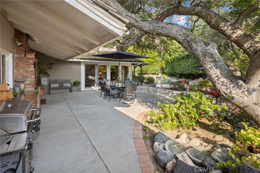 1820 Alta Oaks Drive Arcadia, CA 91006 - Photo 40 of 56 a patio with a table and chairs under an umbrella