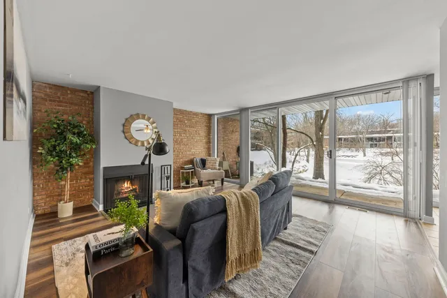 a living room with fireplace furniture and a large window
