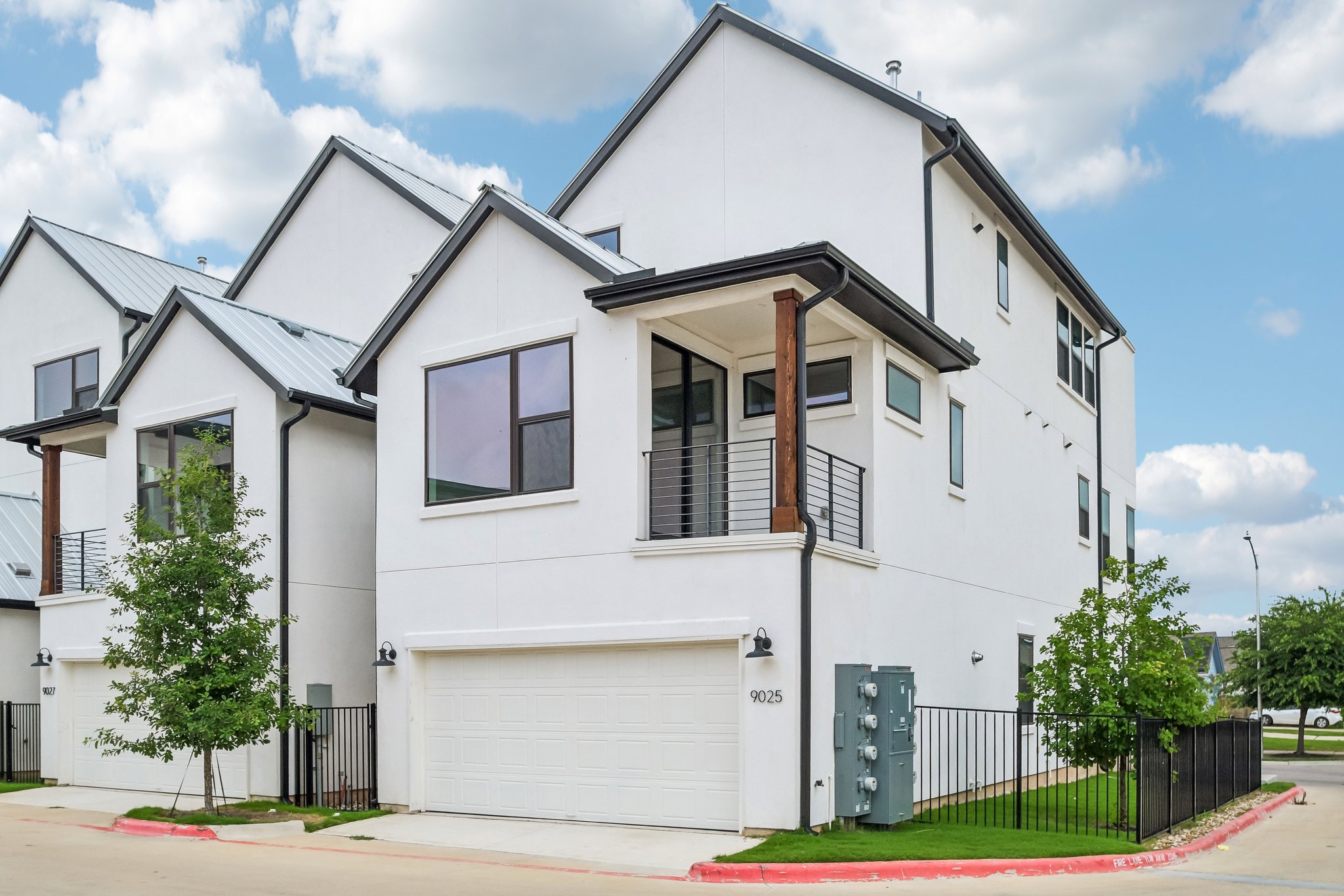 9025 Cattle Baron Path Austin, TX 78747 - Photo 29 of 32 Modern townhomes showcasing crisp white exteriors and sleek architectural lines.