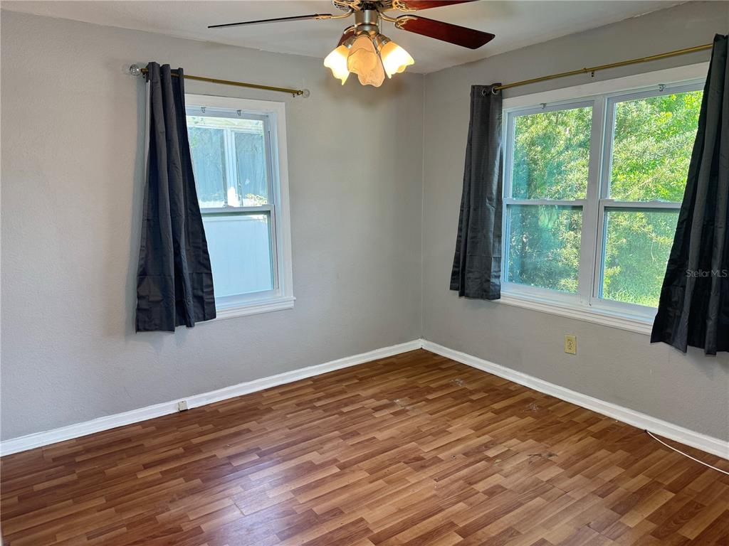 1009 Druid Road Clearwater, FL 33756 - Photo 5 of 9 a view of an empty room with wooden floor and a window
