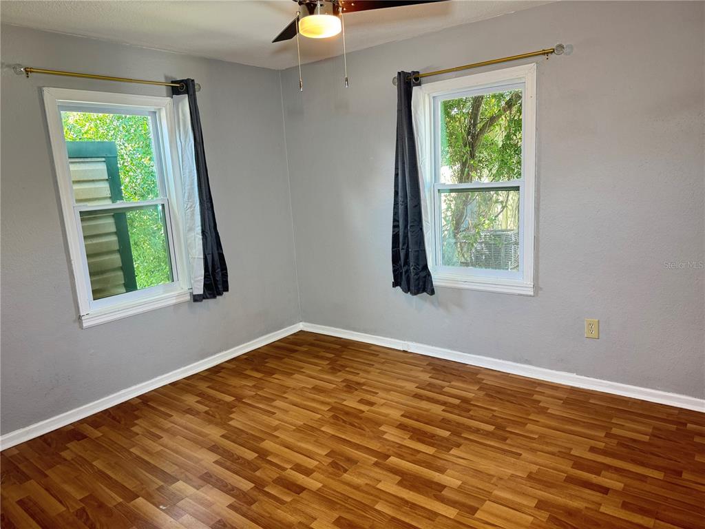 1009 Druid Road Clearwater, FL 33756 - Photo 6 of 9 a view of an empty room with wooden floor and a window