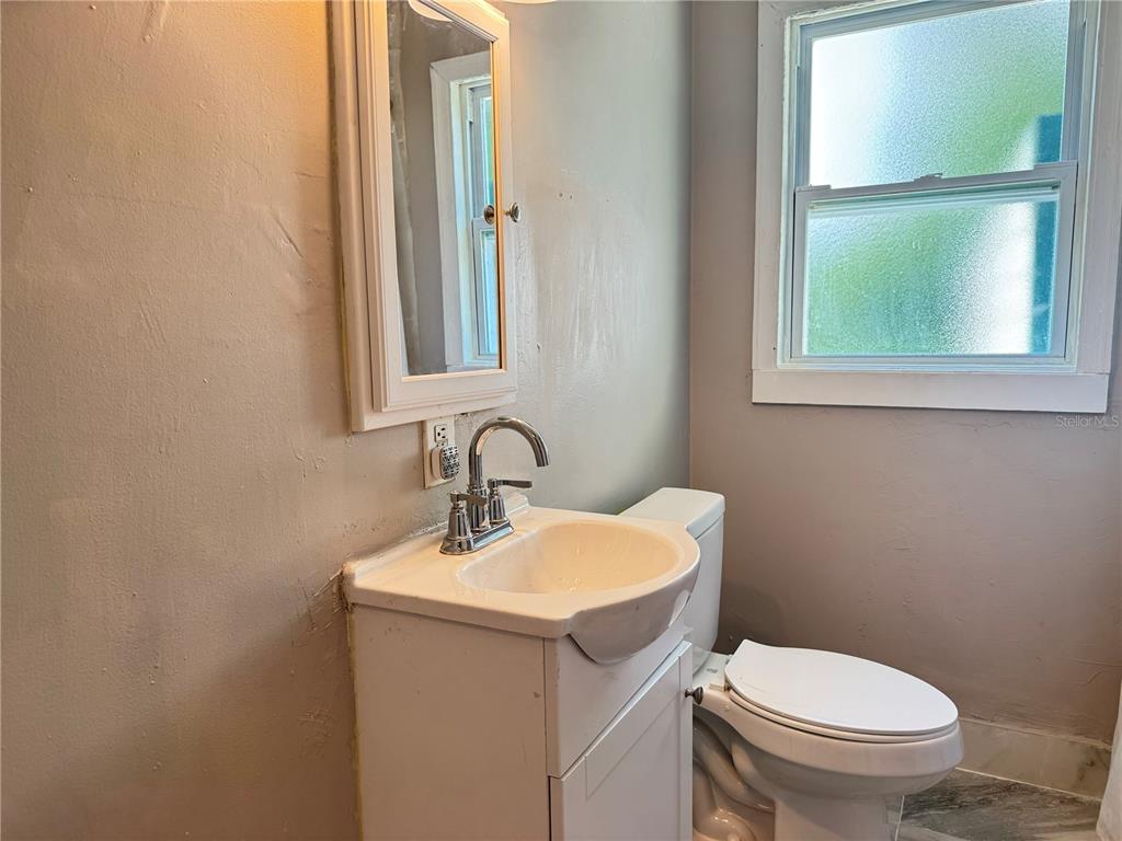 1009 Druid Road Clearwater, FL 33756 - Photo 8 of 9 a bathroom with a toilet sink and mirror