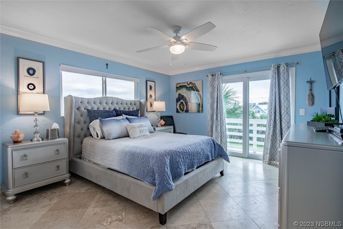 6531 Turtlemound Road New Smyrna Beach, FL 32169 - Photo 11 of 42 a bedroom with a large bed and a chandelier fan