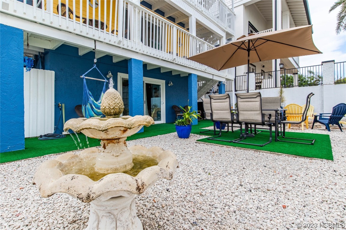 6531 Turtlemound Road New Smyrna Beach, FL 32169 - Photo 34 of 42 a view of a table and chairs under an umbrella