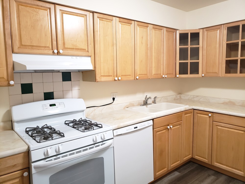 10369 Dearlove Road, Unit 1C Glenview, IL 60025 - Photo 2 of 9 a kitchen with kitchen island a sink a stove and white cabinets