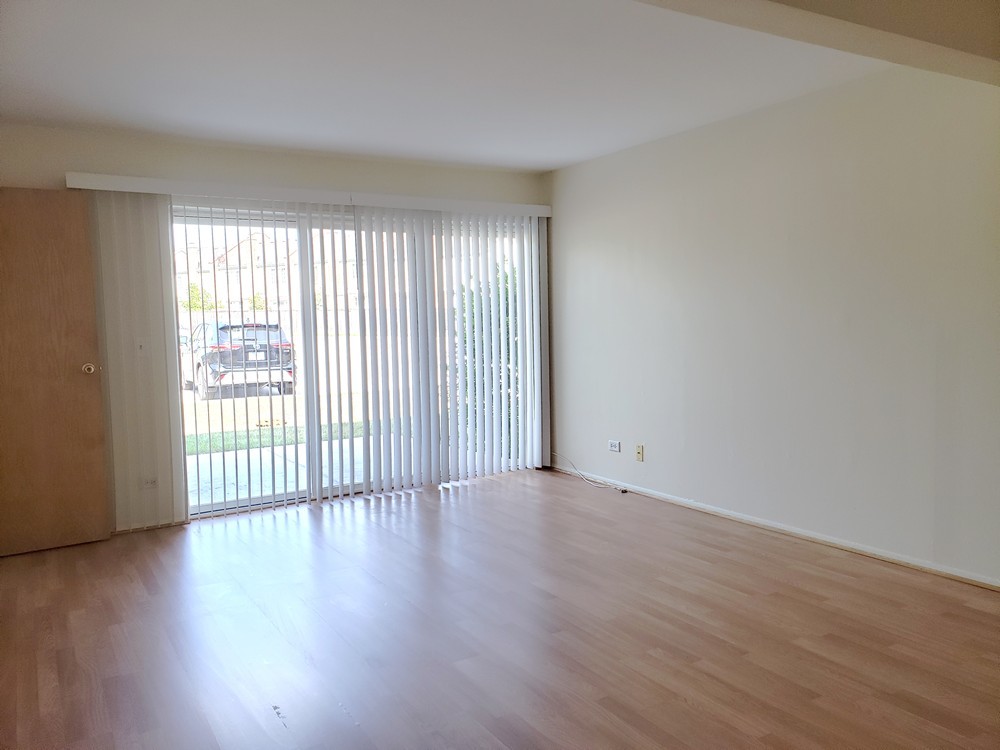 10369 Dearlove Road, Unit 1C Glenview, IL 60025 - Photo 4 of 9 a view of an empty room with wooden floor and a window