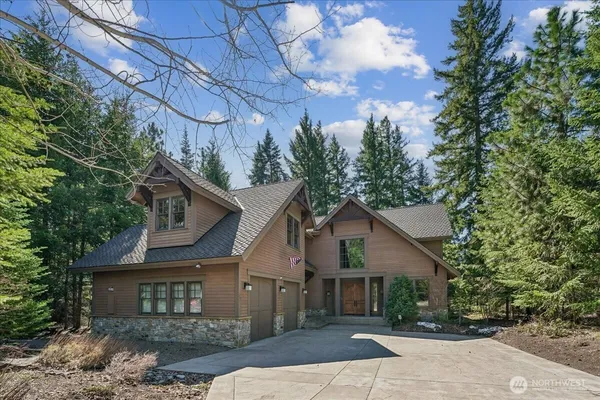 a front view of a house with a garden and trees