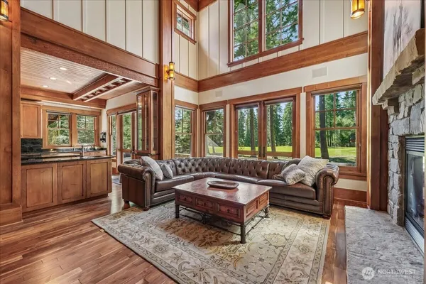 a living room with furniture a rug and a floor to ceiling window