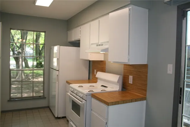 a kitchen with a stove a refrigerator and a window