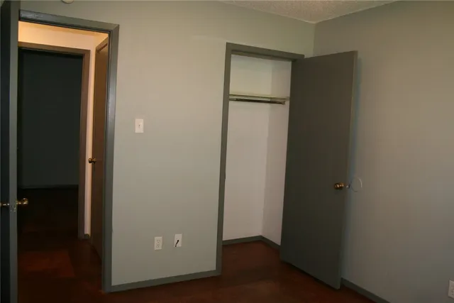 an empty room with wooden floor and closet