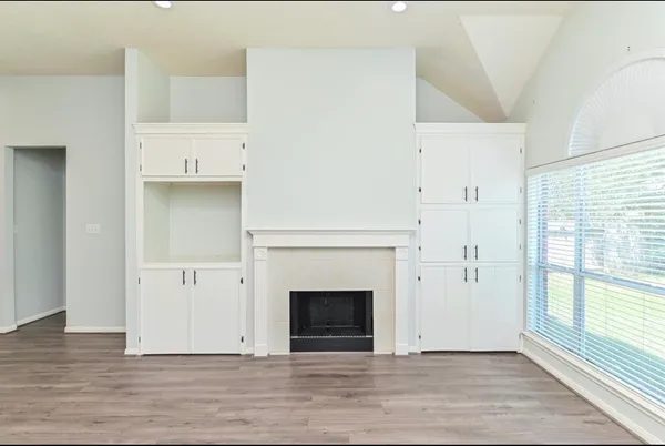 a view of a livingroom with wooden floor and a fireplace