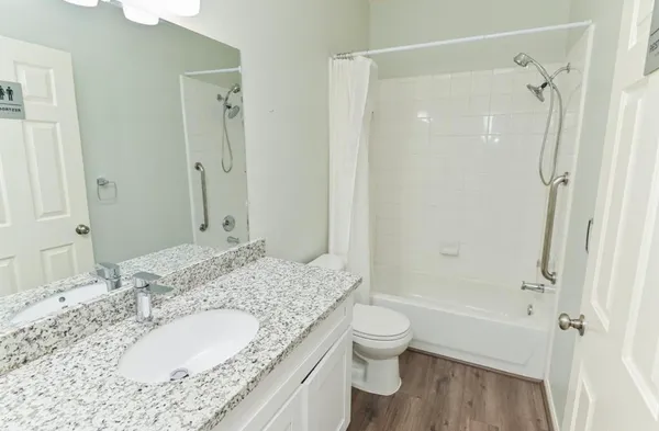 a bathroom with a granite countertop sink toilet and shower