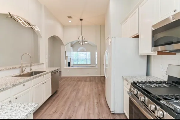 a kitchen with a sink stove top oven and microwave