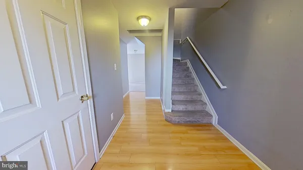 a view of a hallway with wooden floor and stairs