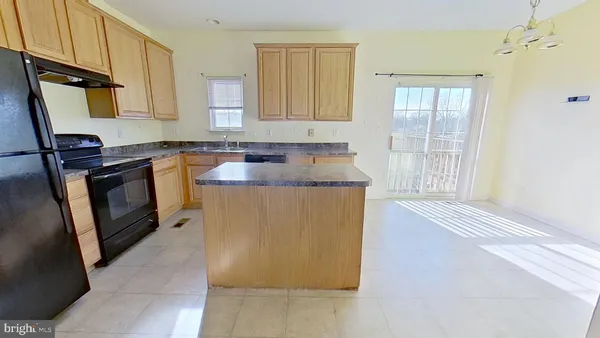a kitchen with granite countertop cabinets stainless steel appliances a sink and a window