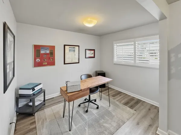 a view of a workspace with furniture and a window