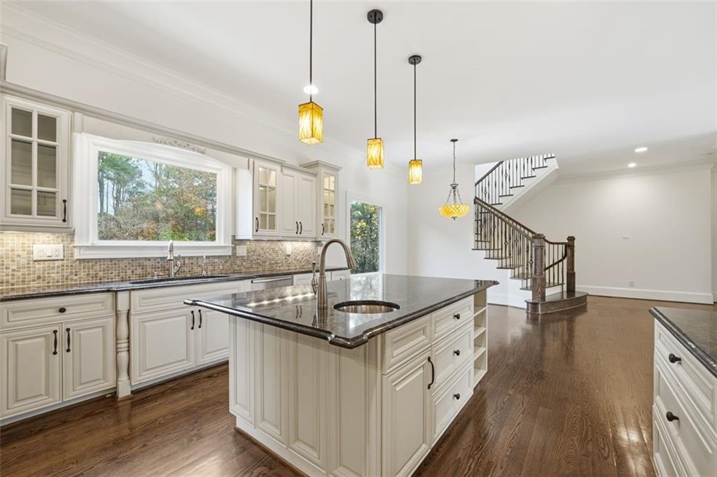 7611 Regency Circle Sandy Springs, GA 30350 - Photo 11 of 74 a kitchen with granite countertop a sink a counter top space and living room view